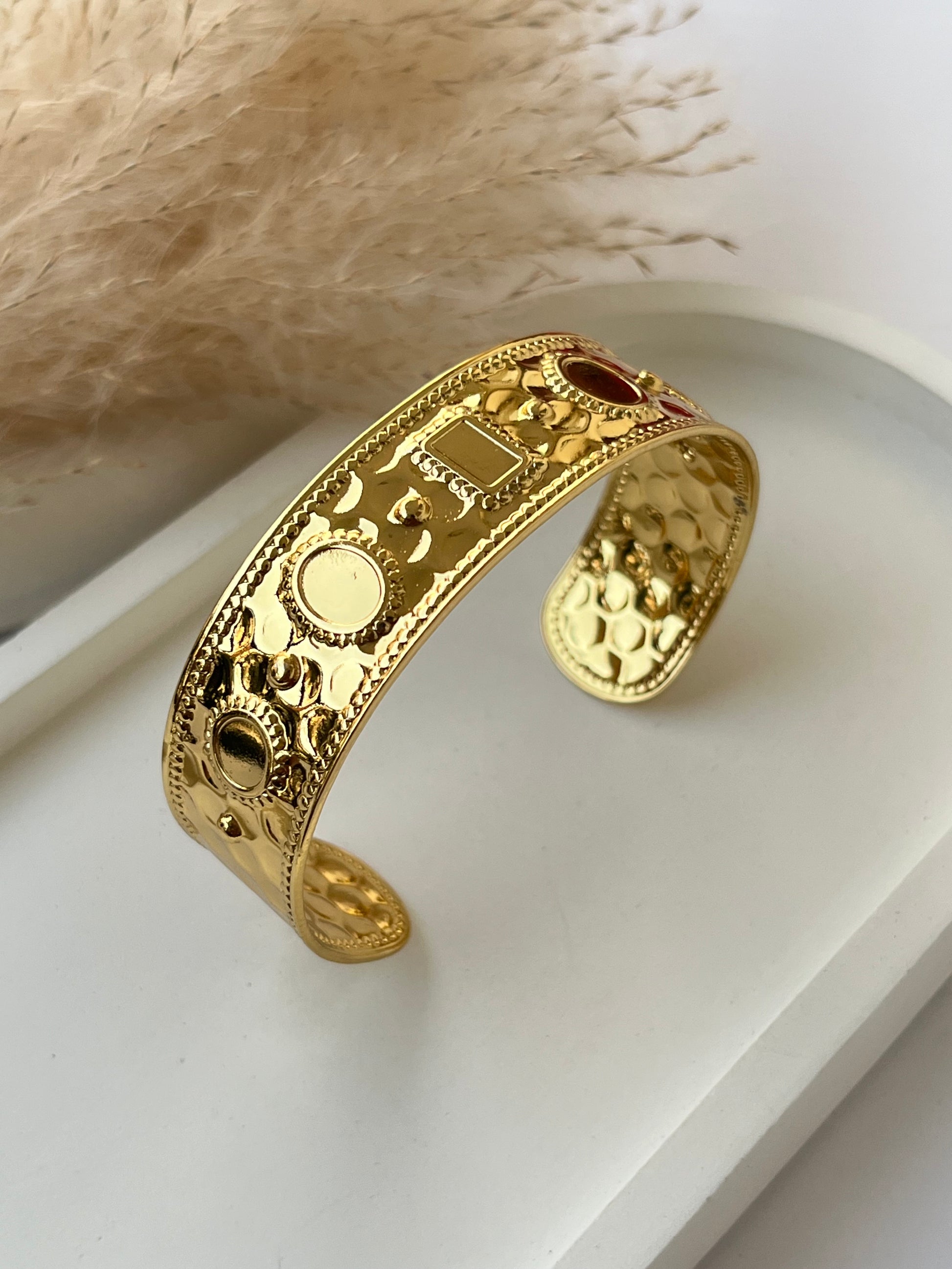 Wide gold cuff bracelet with embossed circular and rectangular motifs, featuring a hammered texture and ornate border – an anti-tarnish statement piece for timeless elegance and bold style.