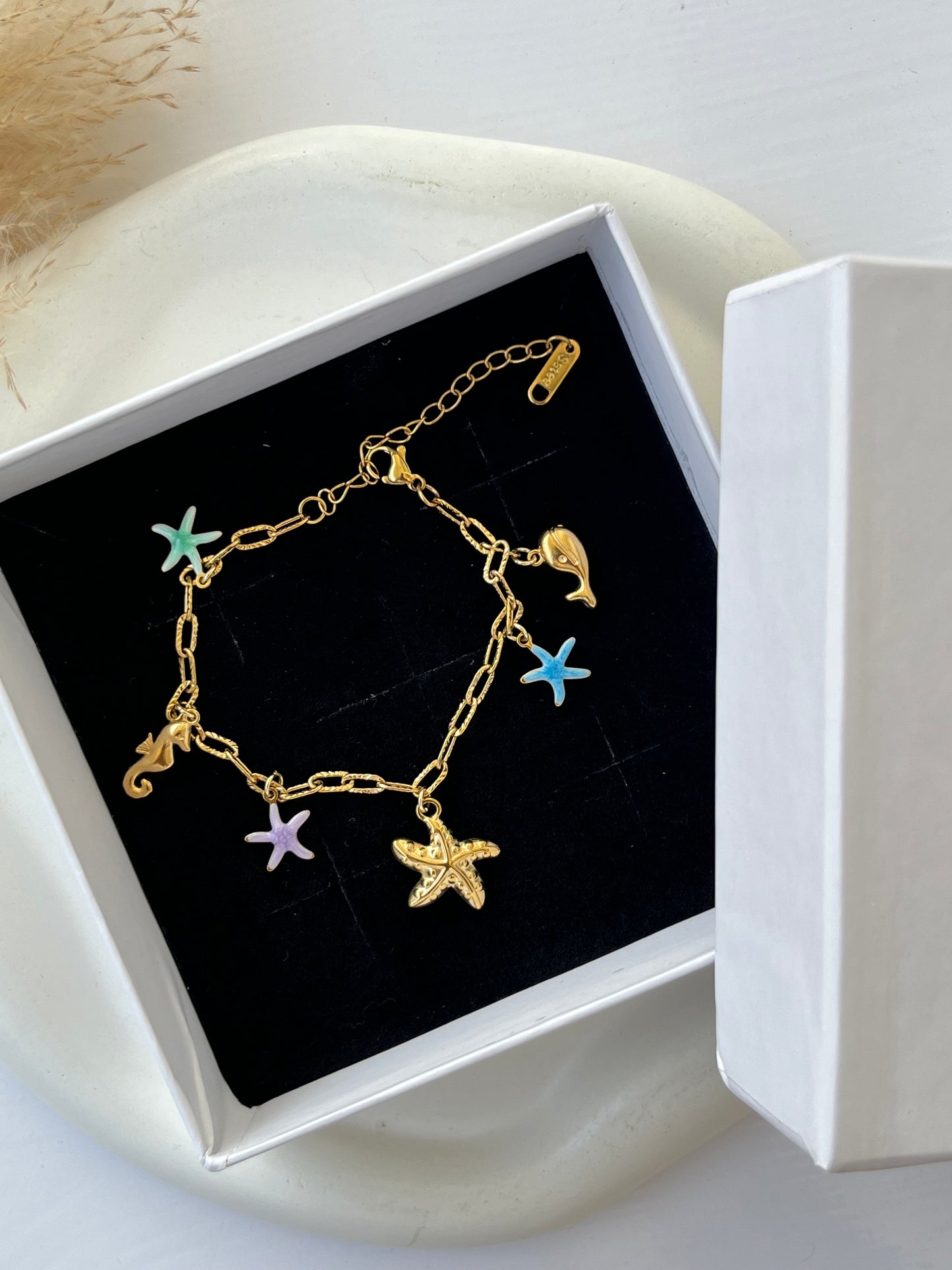 Gold link bracelet with colorful enamel ocean-themed charms – starfish, seahorse, dolphin – an anti-tarnish, playful piece perfect for beach lovers or adding a fun pop to casual looks.
