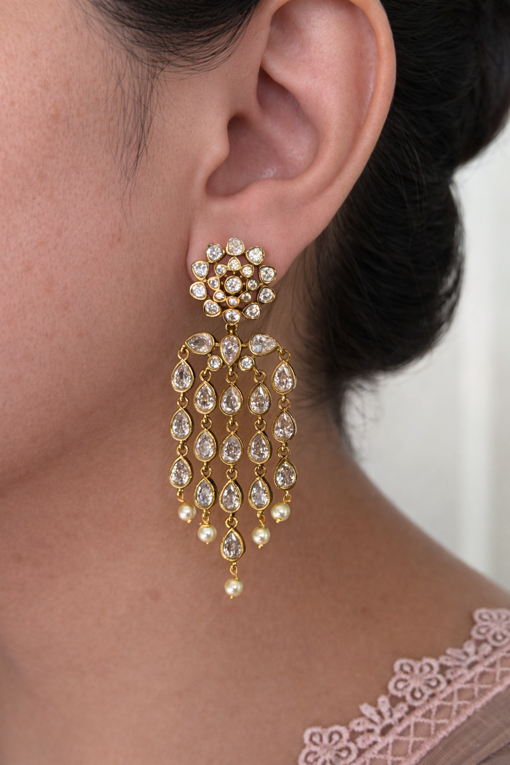 Close-up of a person wearing a diamond look alike and crystal earring with a blurred background