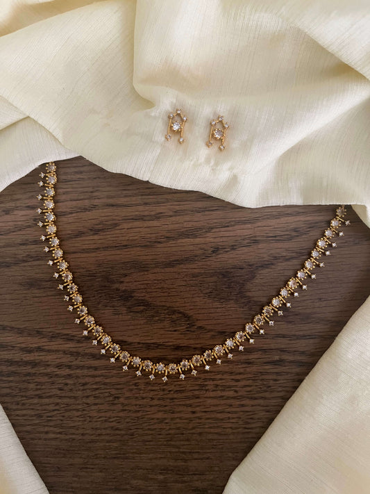 Gold finish American Diamond necklace with matching stud earrings on fabric backdrop – lightweight affordable jewellery set