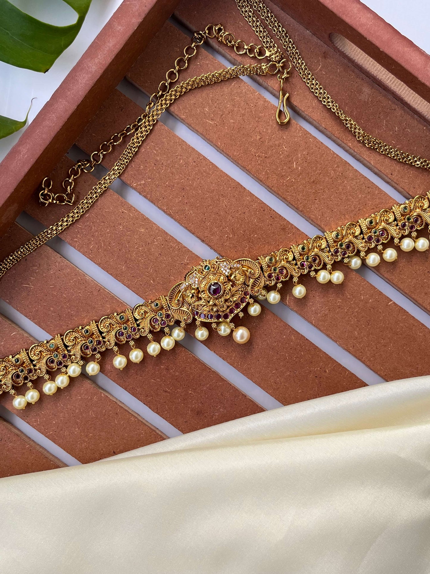Gold necklace with pearls on a textured surface