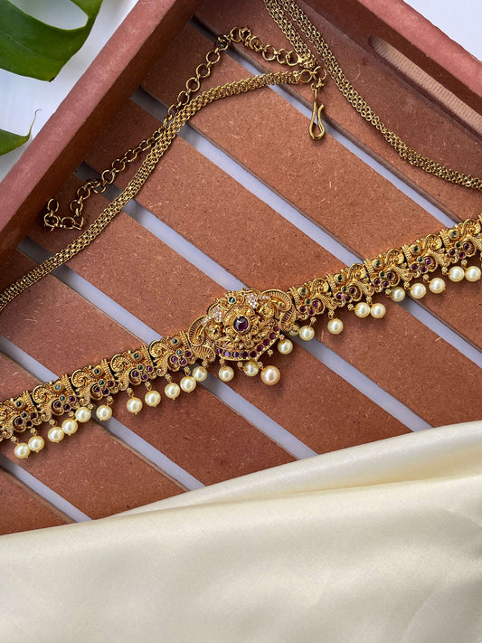 Gold necklace with pearls on a textured surface