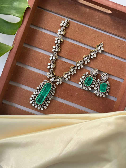 Jewelry set with green stones on a wooden tray
