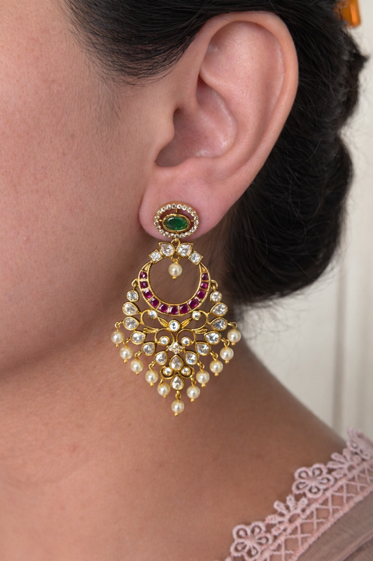 Gold and pearl chaandbali premium earring worn by a person with a neutral background